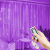 A hand holds a remote control for USB-powered LED curtain lights illuminating purple sheer fabric.