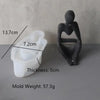 A white silicone mold with dimensions 13.7cm by 7.2cm and a thickness of 5cm, next to a dark, abstract silicone mold.
