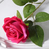 A vibrant pink velvet artificial rose with green leaves on a white background.