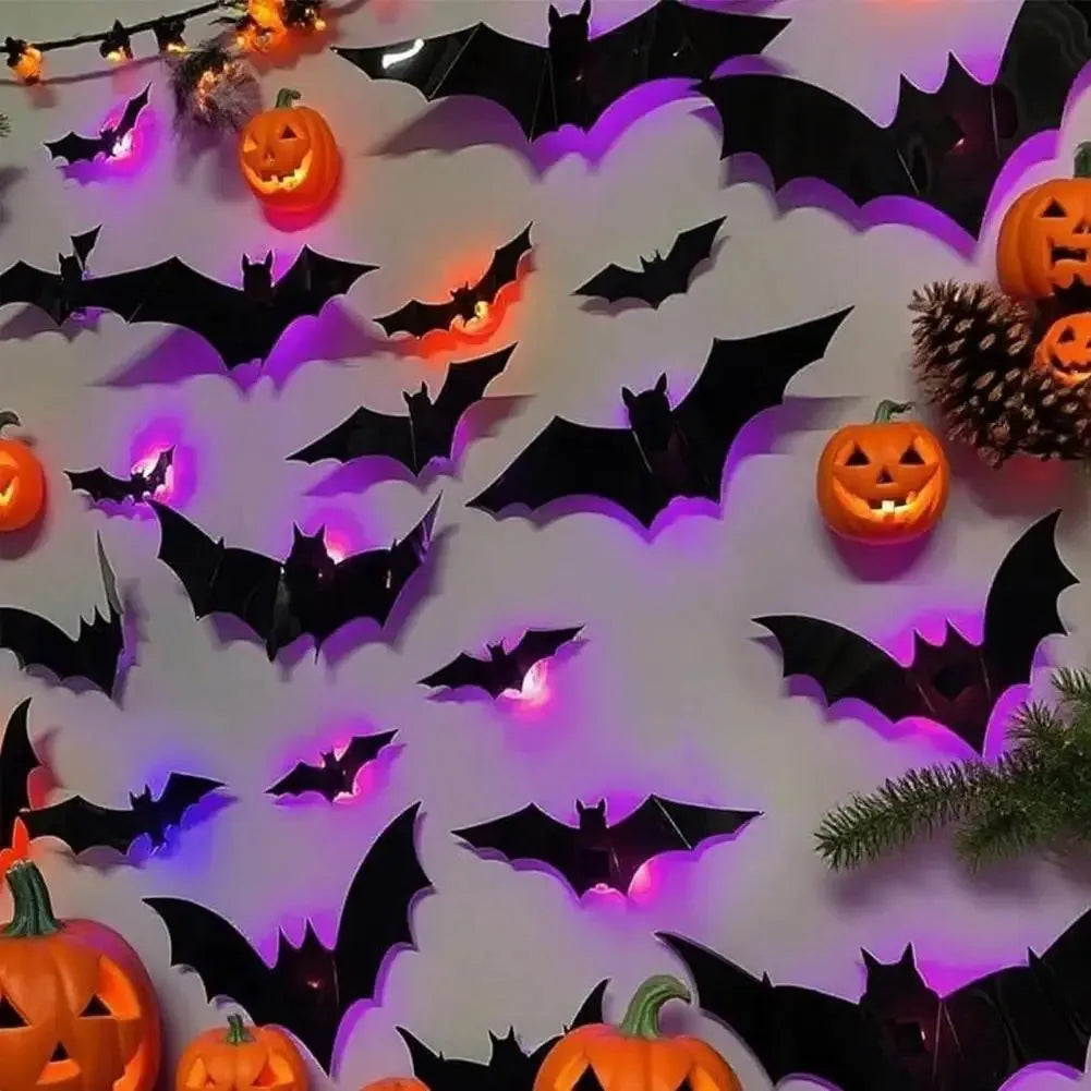 A wall decorated with black bat decals illuminated by colorful LED lights, featuring carved pumpkins and pine branches.