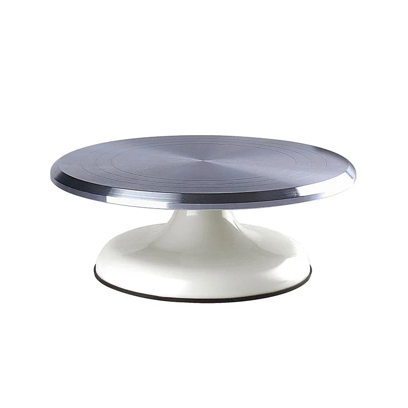 A round, silver aluminum cake turntable with a white pedestal base.