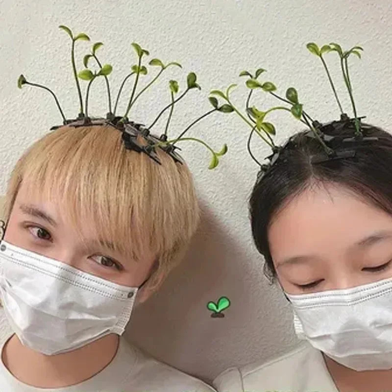 Two women wearing white face masks with bean sprout hair clips featuring small green grass tops