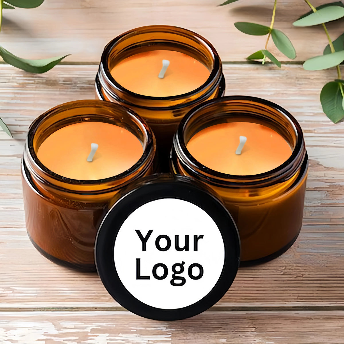 Three amber glass jars filled with orange scented soy wax candles and a black logo stamp on the front.