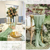 Light blue cheesecloth table runner draped on a rustic wooden chair in an outdoor setting.