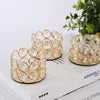 A set of gold-toned crystal candle lantern holders with round glass elements displayed on a white box.