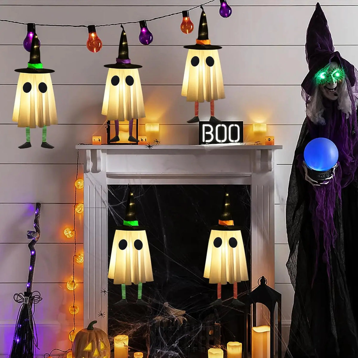 Halloween hanging ghost lights with witch hats decorating a fireplace mantel and dark background