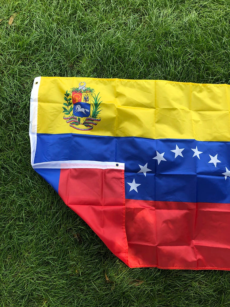 A vibrant Venezuelan national flag banner displayed on green grass.