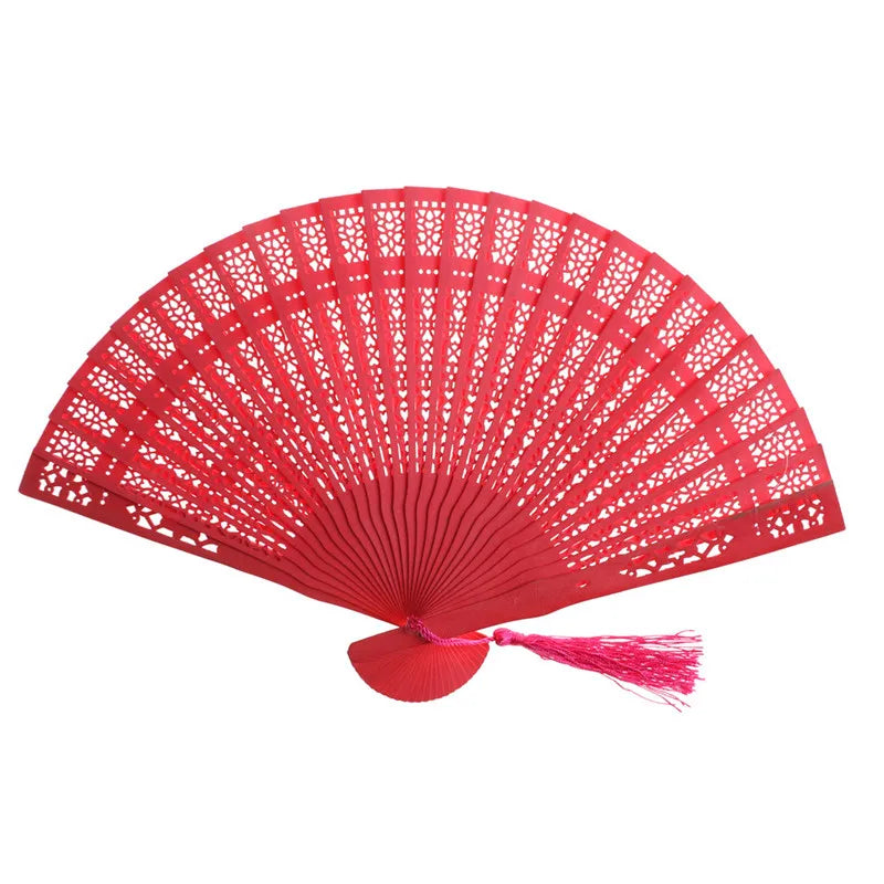 A vibrant red hand carved bamboo folding fan with intricate lattice work.