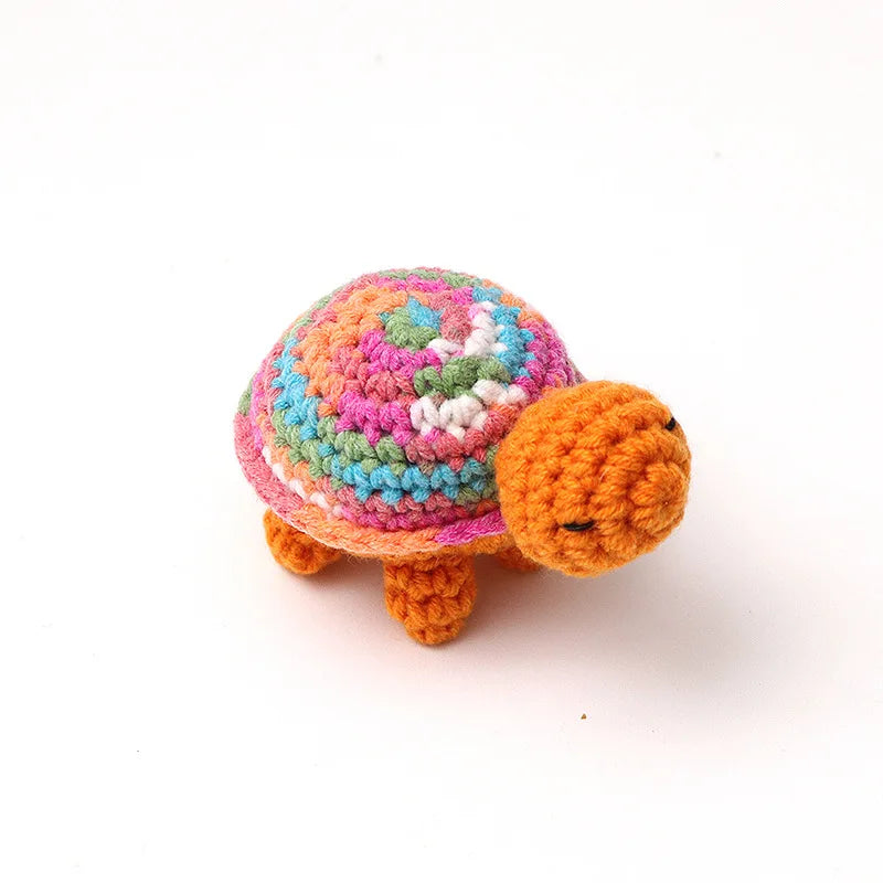 Handmade crocheted turtle plush with colorful patterned shell and orange body