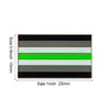 A rectangular lapel pin featuring five horizontal stripes of black, gray, white, and green.