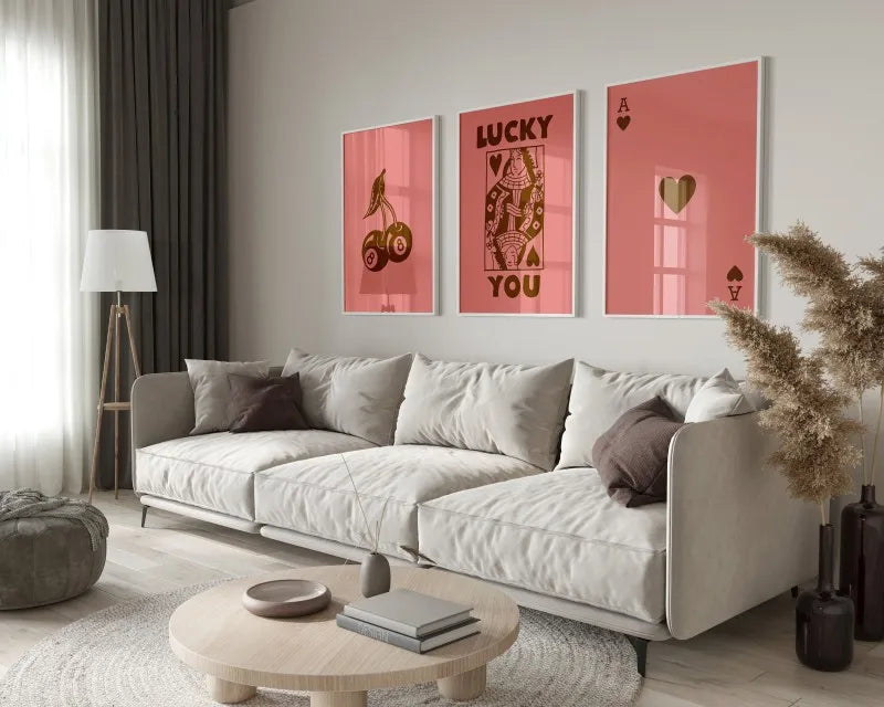 A modern living room features a light sofa and wooden table with framed retro letter art canvases on the wall.
