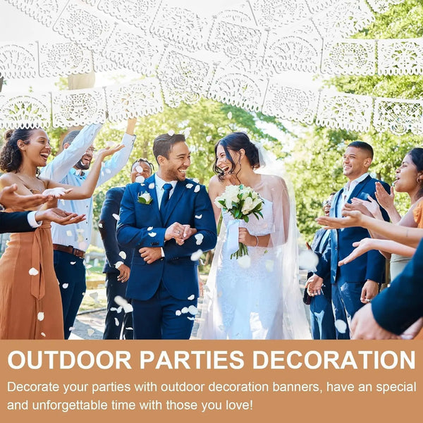 A group of happy people celebrating outdoors with a white decorative banner in the background.