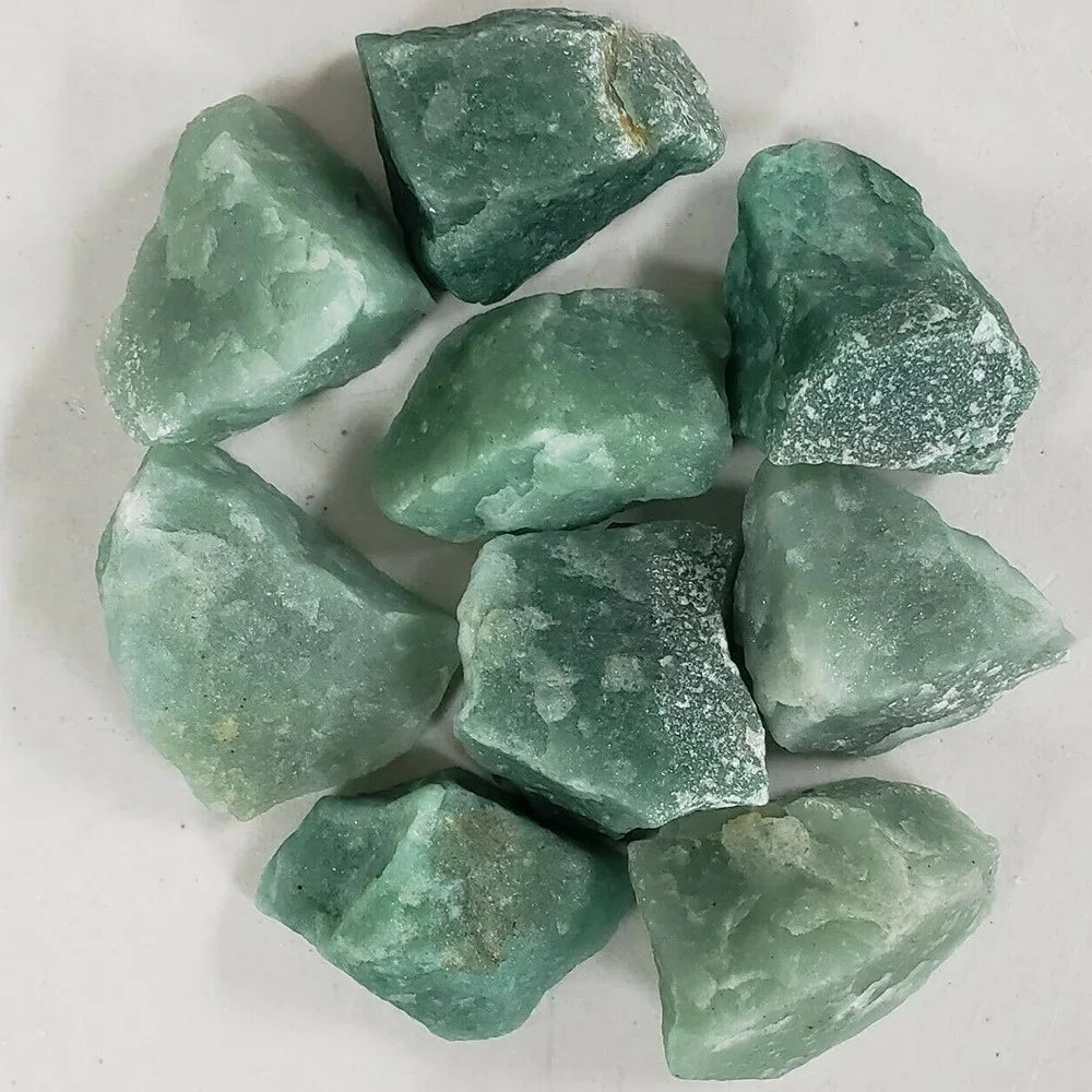 A cluster of raw green aventurine crystal stones, showing various shades of seafoam green and pale blue-green.