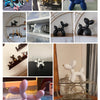 A collection of blue and black Nordic balloon dog resin sculptures displayed on various surfaces.