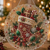 A round, glittery ornament featuring a red Christmas stocking decorated with pearls and greenery.