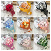 A collection of artificial rose flower bouquets in various colors and packaging, including red, orange, pink, and white roses