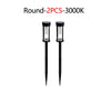 Two round solar pathway lights with LED bulbs and black fixtures.