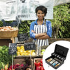 Black lockable metal cash box with an organizer tray and two keys displayed in a market setting.