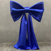 A royal blue satin bow with long tulle drape used for event decoration.