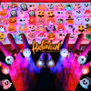 A close-up of a hand holding a tray of colorful Halloween glow rings and light-up party favors.