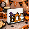 A wooden tissue dispenser featuring a black bat-like design and an orange pumpkin pattern.