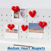 A set of red heart-shaped fridge magnets featuring various photographic and text designs.