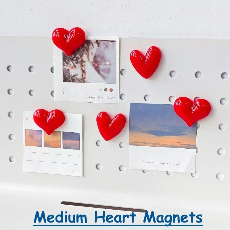 A set of red heart-shaped fridge magnets featuring various photographic and text designs.