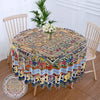 Bohemian peacock mandala round tablecloth displayed on a wooden table with a white wooden chair in a bright room.