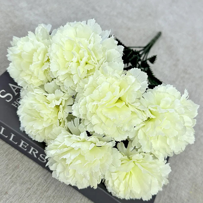 A bouquet of white silk artificial chrysanthemum flowers displayed on a dark surface.