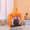 An orange Halloween themed non-woven gift tote bag with a yellow handle and festive print displayed on a wooden surface.