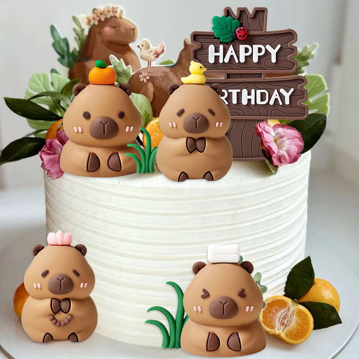 A white cake decorated with adorable brown bear fondant toppers and natural greenery for a birthday party.