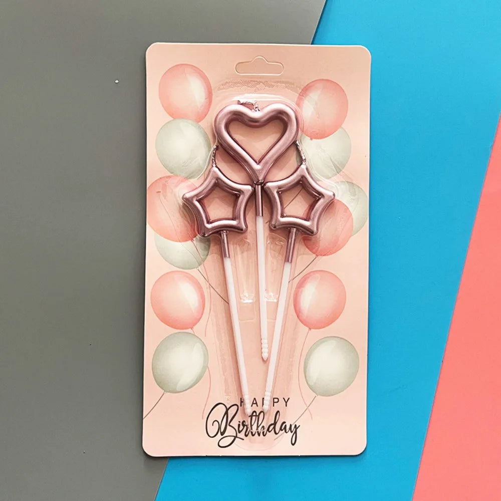 A pink cardboard packaging for a set of metallic heart and star birthday candles against a blue background.