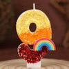 Rainbow sequined number candles shaped like the number 0 and a rainbow on a white base