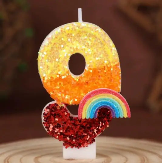 Rainbow sequined number candles shaped like the number 0 and a rainbow on a white base