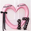 Pink heart-shaped balloon decoration with black lettering and a number 7