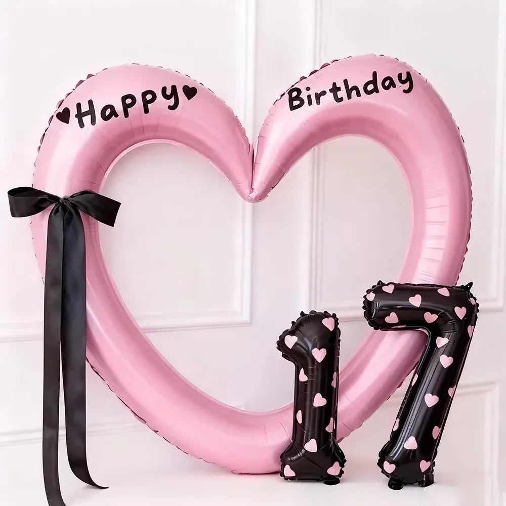Pink heart-shaped balloon decoration with black lettering and a number 7