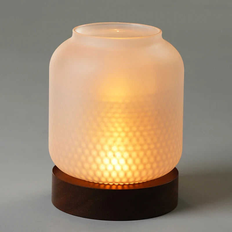 A vintage wooden candle lantern with a translucent glass cover emits a warm, glowing light.