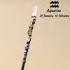 A natural clear quartz zodiac crystal wand with gold accents and blue stones, suitable for meditation and healing.