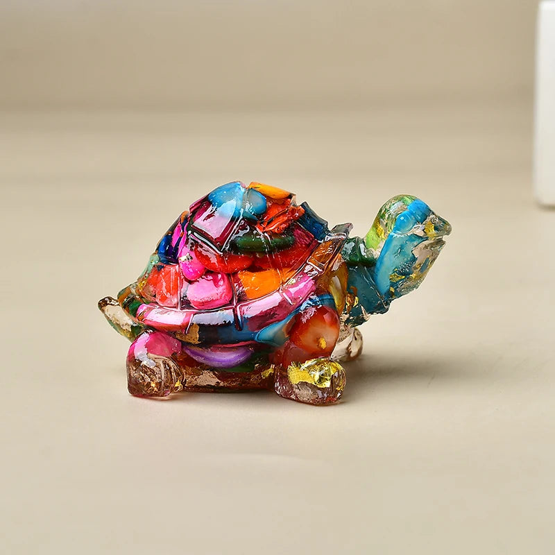 Bunte Kristall-Schildkrötenfigur mit irisierenden Schuppen und strukturiertem Körper auf heller Oberfläche.