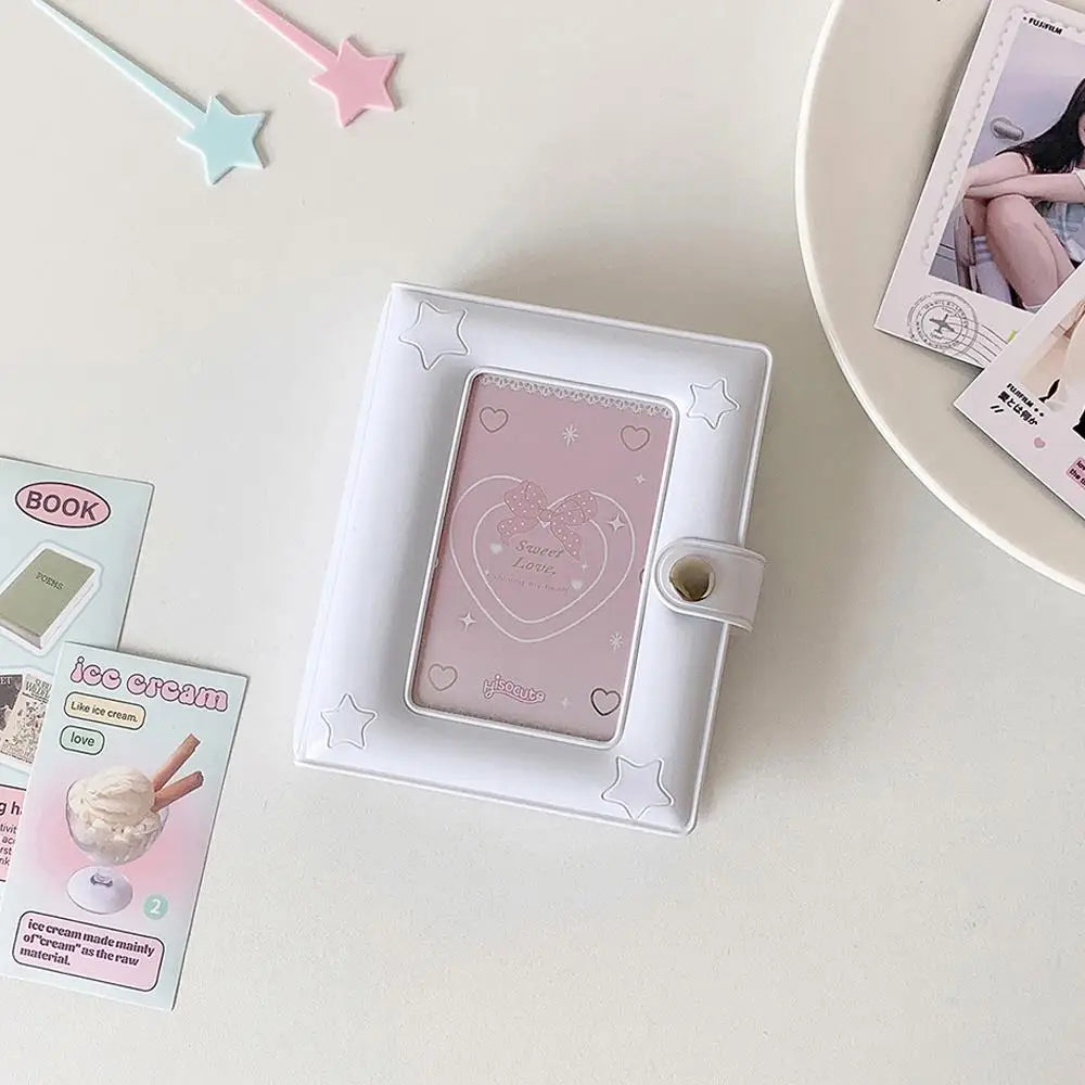 A white compact star-shaped photo card holder album with a pink cover and a clear window is displayed on a light surface.