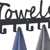 Black decorative metal wall-mounted towel rack with seven hooks displaying folded towels.