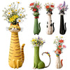 A collection of whimsical resin cat flower vases in various colors and styles.