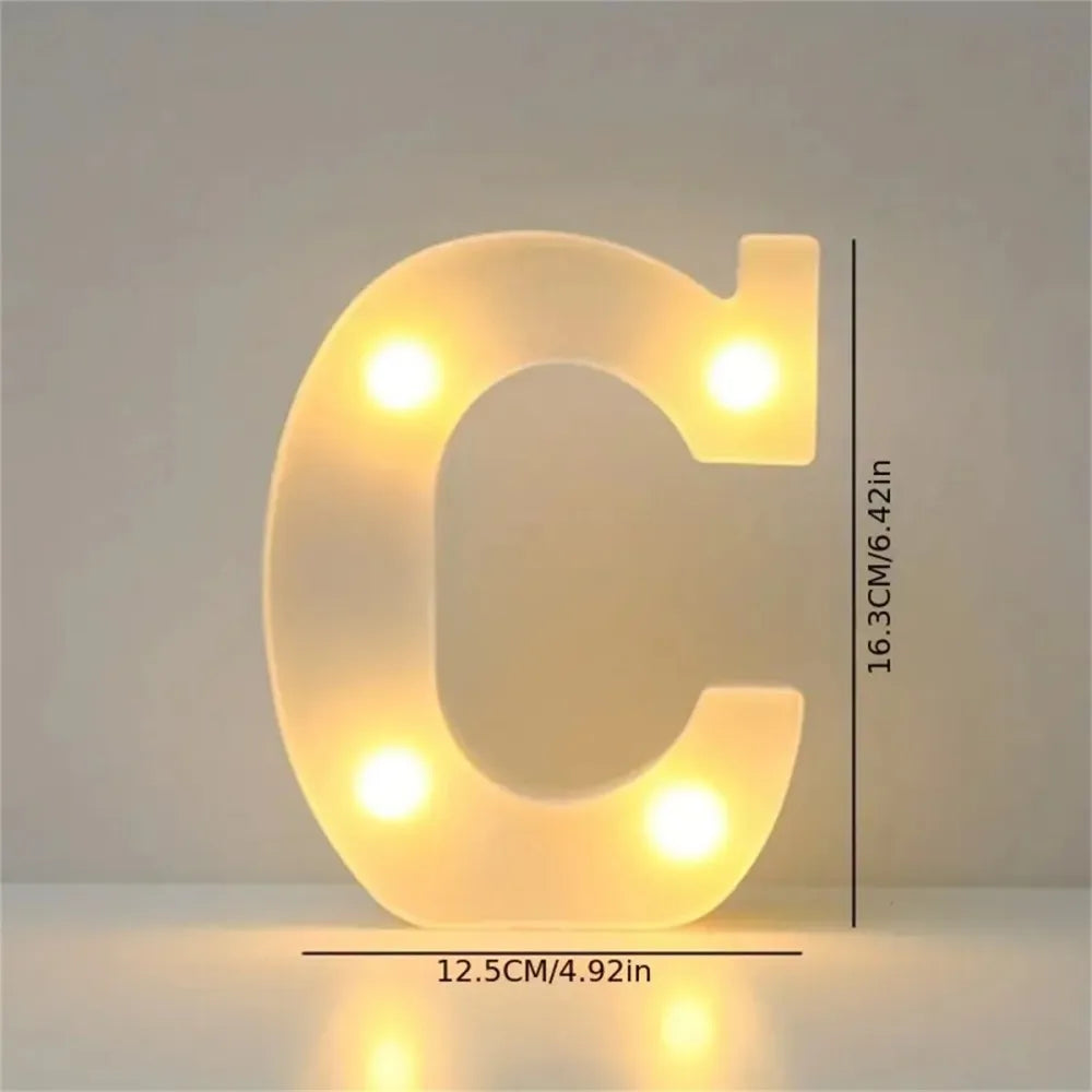 A glowing white LED letter C light fixture used for room or party decor.