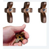 Three wooden crosses with epoxy hearts shown next to a hand for scale