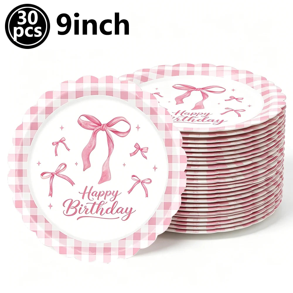 A stack of pink gingham paper plates decorated with pink bows for a birthday party.