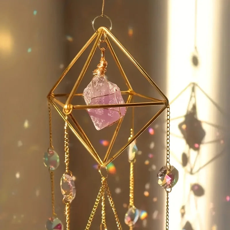 A hanging geometric gold crystal suncatcher featuring a clear amethyst pendant and dangling crystal beads.