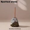 A stick of spotted stone is placed into a natural rock for use in aromatherapy.