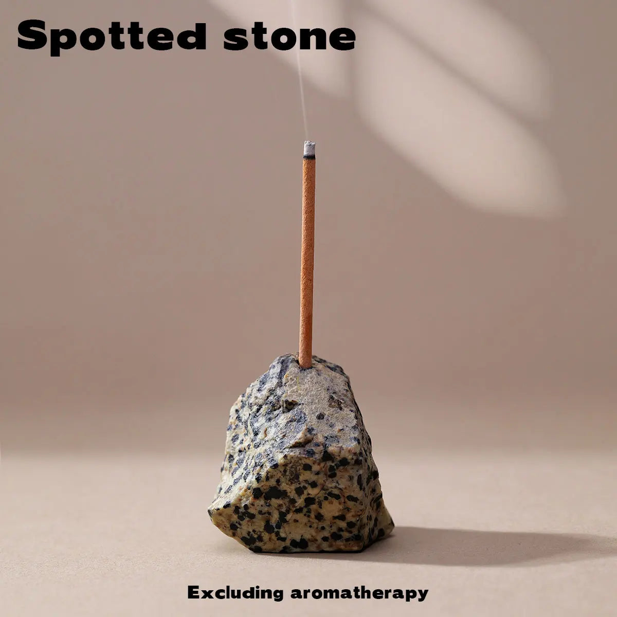 A stick of spotted stone is placed into a natural rock for use in aromatherapy.
