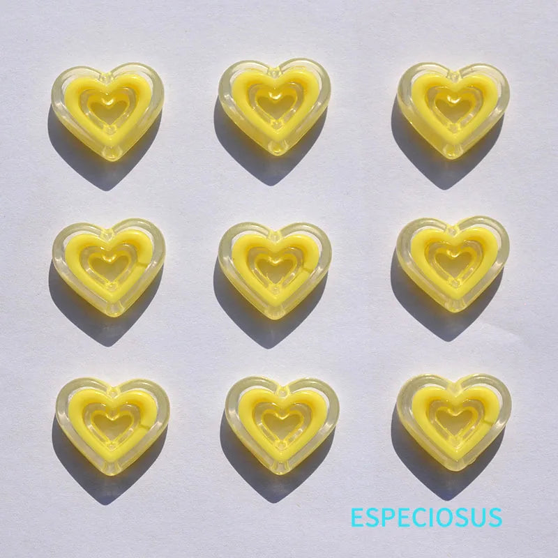 A set of yellow heart-shaped acrylic charms against a white background.