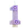 A purple sparkling number candle shaped like the number one with a small flower decoration.